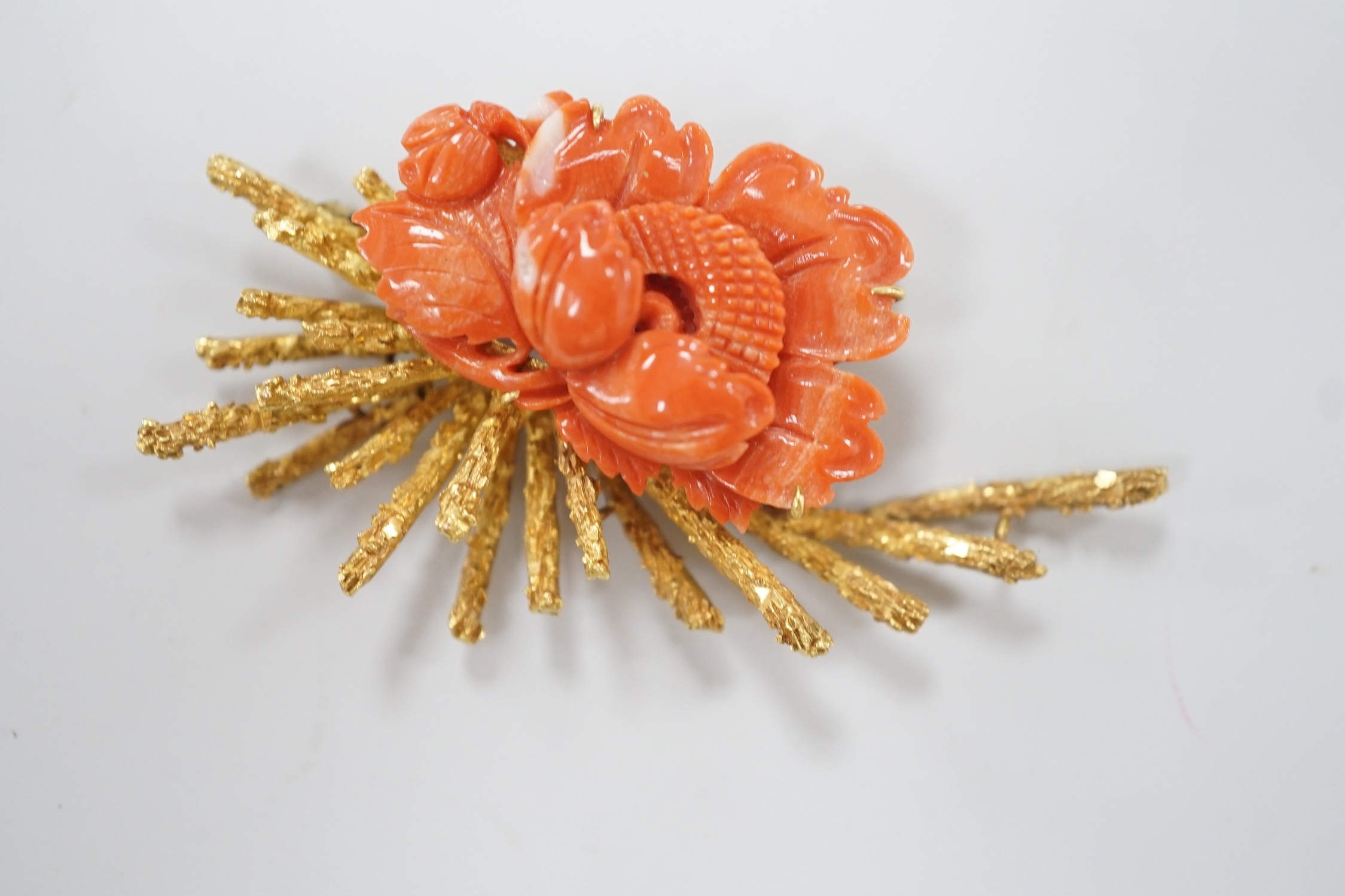 A 1970's? textured 14k yellow metal and carved coral mounted floral spray brooch, 62mm, gross weight 17.1 grams.